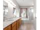 Bright bathroom featuring a double vanity, granite countertops, a bathtub, and a glass-enclosed shower at 9415 Se 125Th St, Summerfield, FL 34491