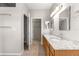Bathroom showcasing double sinks, granite countertop, wood cabinetry, and walk-in closet access at 9415 Se 125Th St, Summerfield, FL 34491