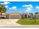 Beautiful home features a three-car garage, custom driveway, and manicured lawn with charming landscaping at 9415 Se 125Th St, Summerfield, FL 34491