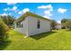 Side exterior view with a well-maintained lawn and mature plantings providing privacy at 9415 Se 125Th St, Summerfield, FL 34491