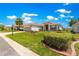 Home featuring a manicured lawn, mature landscaping, and a spacious three-car garage at 9415 Se 125Th St, Summerfield, FL 34491