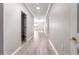 Hallway with light gray walls and wood floors leading to an open living room with natural light at 9415 Se 125Th St, Summerfield, FL 34491