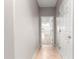 Hallway with light gray walls and tile floor leading into an open living area with hardwood flooring at 9415 Se 125Th St, Summerfield, FL 34491