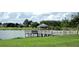 Scenic lake view featuring a fishing pier and gazebo, offering serene waterfront relaxation and recreational opportunities at 9415 Se 125Th St, Summerfield, FL 34491