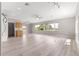 Bright living room features hardwood floors, ceiling fan and large window with a view of a lake at 9415 Se 125Th St, Summerfield, FL 34491