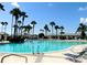 Large community pool is surrounded by palm trees and comfortable lounge chairs for residents at 9415 Se 125Th St, Summerfield, FL 34491