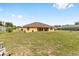The yellow back exterior looks out onto a large grassy backyard, partially fenced at 9562 Sw 45Th Ave, Ocala, FL 34476