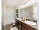 Well-lit bathroom featuring double sink vanity, shower over tub, and wood look flooring at 9562 Sw 45Th Ave, Ocala, FL 34476