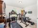 Carpeted exercise room featuring treadmill, elliptical machine, and weight equipment at 9562 Sw 45Th Ave, Ocala, FL 34476