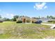Charming one-story house showcasing a manicured front lawn and a lengthy driveway to the attached two-car garage at 9562 Sw 45Th Ave, Ocala, FL 34476