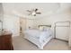 Main bedroom featuring carpeted floors, a tray ceiling, a ceiling fan, and a window at 9562 Sw 45Th Ave, Ocala, FL 34476