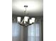 Contemporary chandelier illuminates the space, complementing the sheer curtains and natural light at 9706 Sw 92Nd Place Rd, Ocala, FL 34481