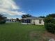 Beautiful home with a screened-in lanai, green lawn, and landscaped yard, creating a tranquil outdoor setting at 9706 Sw 92Nd Place Rd, Ocala, FL 34481