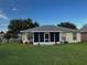 Charming home exterior featuring a screened-in lanai, well-manicured lawn, and lush landscaping, blending indoor/outdoor living at 9706 Sw 92Nd Place Rd, Ocala, FL 34481