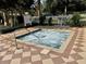 Private hot tub surrounded by a tiled patio, white fencing, and lush landscaping at 9706 Sw 92Nd Place Rd, Ocala, FL 34481