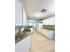 Well-lit kitchen with white appliances, laminate countertops and flooring, and ample cabinet space at 9706 Sw 92Nd Place Rd, Ocala, FL 34481