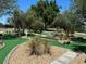 A well-manicured putting green with lush green turf, decorative rocks, and landscaping for leisurely play at 9706 Sw 92Nd Place Rd, Ocala, FL 34481