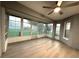 Comfortable sunroom with a ceiling fan, wood-look flooring, and an abundance of natural light through large windows at 9706 Sw 92Nd Place Rd, Ocala, FL 34481