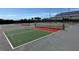 Outdoor tennis courts with a grey, green, and red color scheme with fencing at 9706 Sw 92Nd Place Rd, Ocala, FL 34481