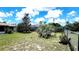 View of a grassy fenced yard, complete with mature palm tree and residential solar panels in the background at 16905 Sw 30Th Avenue Rd, Ocala, FL 34473
