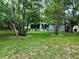 View of home and fenced-in backyard with flourishing trees and a screened in lanai at 10130 Sw 61St Terrace Rd, Ocala, FL 34476
