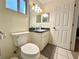 Bathroom featuring a toilet, single sink vanity with a grey countertop, and white cabinets at 10130 Sw 61St Terrace Rd, Ocala, FL 34476