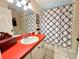 Bathroom featuring a vibrant vanity top, large mirror, patterned shower curtain, and neutral tile flooring at 10130 Sw 61St Terrace Rd, Ocala, FL 34476
