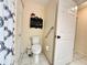 Bright bathroom with a toilet, storage shelves, tile flooring, and white door at 10130 Sw 61St Terrace Rd, Ocala, FL 34476