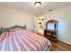 Comfortable bedroom with wood floors, a bed with a striped comforter, and furniture at 10130 Sw 61St Terrace Rd, Ocala, FL 34476