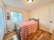 Bright bedroom with a striped comforter, wood floors, natural light, and a closet at 10130 Sw 61St Terrace Rd, Ocala, FL 34476