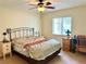 Cozy bedroom featuring a bed with floral bedding, a ceiling fan, carpet, and two bedside tables with lamps at 10130 Sw 61St Terrace Rd, Ocala, FL 34476
