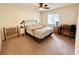 Cozy bedroom features a bed with floral bedding, a ceiling fan, carpet, and two bedside tables with lamps at 10130 Sw 61St Terrace Rd, Ocala, FL 34476