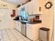 Bright kitchen features white cabinetry, stainless steel appliances, a double sink, and neutral tile flooring at 10130 Sw 61St Terrace Rd, Ocala, FL 34476