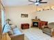 Cozy living room featuring neutral walls, tile flooring, and a wood-burning fireplace at 10130 Sw 61St Terrace Rd, Ocala, FL 34476