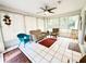 Sunroom featuring tile flooring, a ceiling fan, and multiple seating options, offering bright space at 10130 Sw 61St Terrace Rd, Ocala, FL 34476
