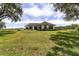 The back of the home features a wide open lawn with large mature trees and a cozy outdoor seating area at 10600 Se 32Nd Ave, Ocala, FL 34480