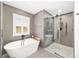 Bathroom featuring freestanding tub and frameless glass shower with gray-toned tile surround at 10600 Se 32Nd Ave, Ocala, FL 34480