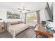 This bedroom features a ceiling fan, stylish decor, and a view of the outdoors at 10600 Se 32Nd Ave, Ocala, FL 34480