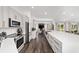 Modern kitchen with stainless steel appliances, expansive island, and a view into the living area at 10600 Se 32Nd Ave, Ocala, FL 34480