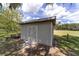 Outdoor shed with double doors, providing extra storage space, and a trailer parked beside it at 10600 Se 32Nd Ave, Ocala, FL 34480
