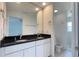 Bright bathroom featuring dual sinks, black granite countertop, and tiled floors at 10758 Se Highway 464C, Ocklawaha, FL 32179