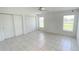 Bedroom featuring tile flooring, neutral walls, ceiling fan, and large windows at 10758 Se Highway 464C, Ocklawaha, FL 32179