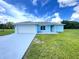 Charming, single story home with a two car garage, gray roof, blue siding and well manicured front lawn at 10758 Se Highway 464C, Ocklawaha, FL 32179