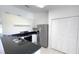 Kitchen featuring stainless steel refrigerator, dark countertops, tile flooring, and pantry with shelving at 10758 Se Highway 464C, Ocklawaha, FL 32179