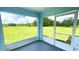 View from a screened lanai overlooking green grass and trees at 10758 Se Highway 464C, Ocklawaha, FL 32179