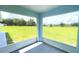 View from a screened lanai overlooking green grass and trees at 10758 Se Highway 464C, Ocklawaha, FL 32179