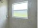 Shower featuring a window and white marble styled tiling at 10758 Se Highway 464C, Ocklawaha, FL 32179