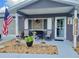 Charming front porch with patriotic decor, inviting seating, and meticulously maintained landscaping at 10945 Sw 75Th Ave, Ocala, FL 34476