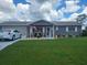 Charming single-story home boasts a well-manicured lawn and inviting covered porch with patriotic decor at 10945 Sw 75Th Ave, Ocala, FL 34476