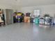 Spacious garage with epoxy floors provides ample storage and laundry space with stainless steel appliances at 10945 Sw 75Th Ave, Ocala, FL 34476
